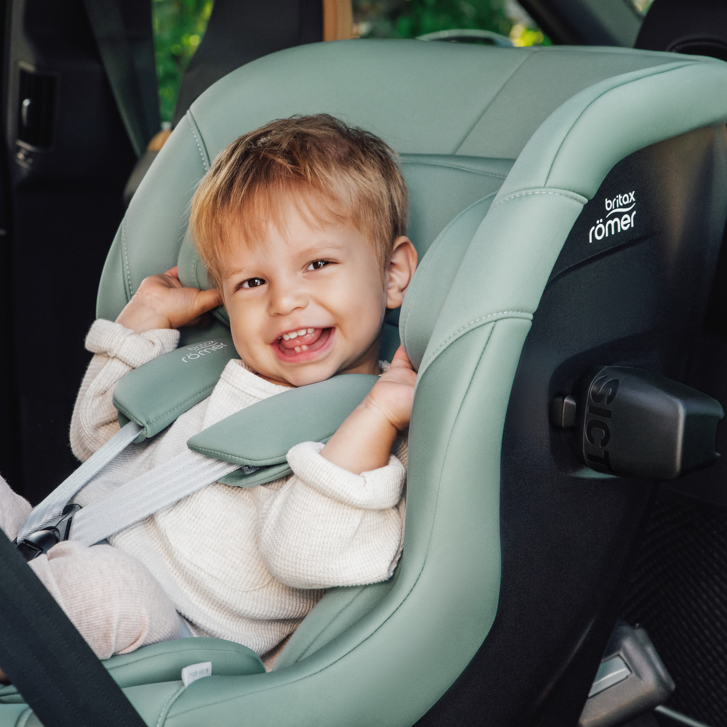 Jeune enfant souriant attach&eacute; dans le si&egrave;ge auto MAX-SAFE PRO en Jade Green.